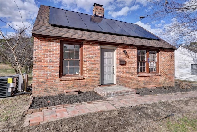 view of front of property with solar panels and cooling unit