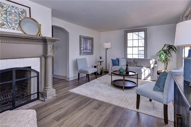 living room with wood-type flooring and a brick fireplace