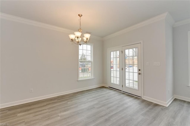 interior space with an inviting chandelier, ornamental molding, a healthy amount of sunlight, and light hardwood / wood-style flooring