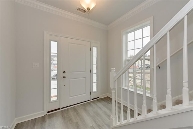 entrance foyer featuring a healthy amount of sunlight, light wood-type flooring, and crown molding