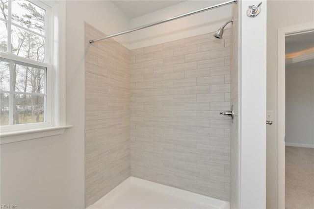 bathroom featuring tiled shower and a wealth of natural light