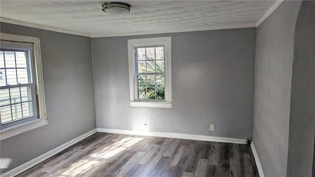spare room featuring baseboards, ornamental molding, and wood finished floors