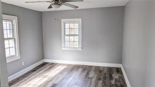 unfurnished room featuring plenty of natural light, baseboards, ceiling fan, and wood finished floors
