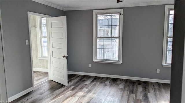 interior space featuring baseboards, ornamental molding, and wood finished floors