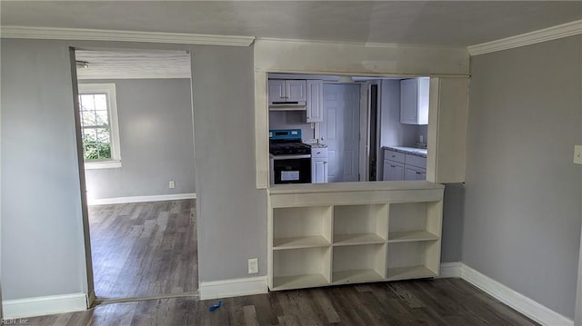 kitchen with crown molding, dark wood-style flooring, stainless steel gas range oven, baseboards, and under cabinet range hood