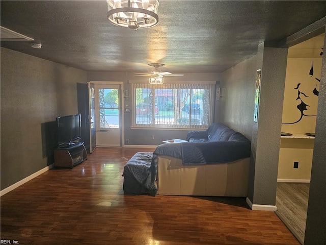 bedroom featuring ceiling fan with notable chandelier, hardwood / wood-style flooring, and multiple windows