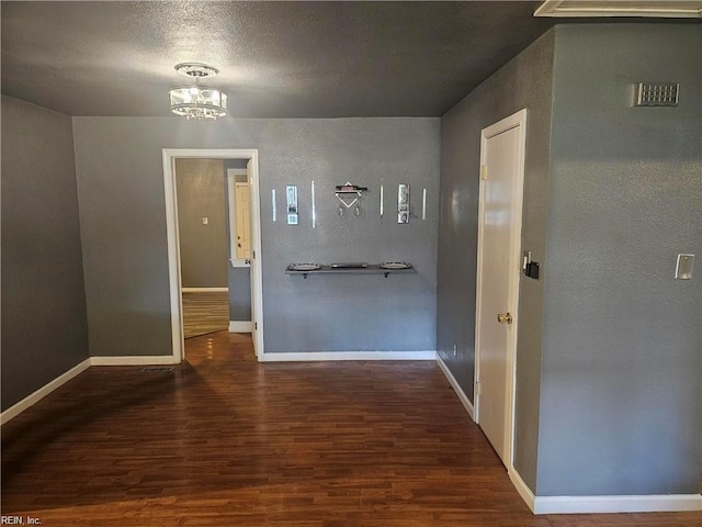 hallway featuring dark wood-type flooring and a chandelier