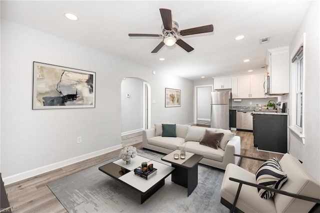 living room with ceiling fan and light hardwood / wood-style floors