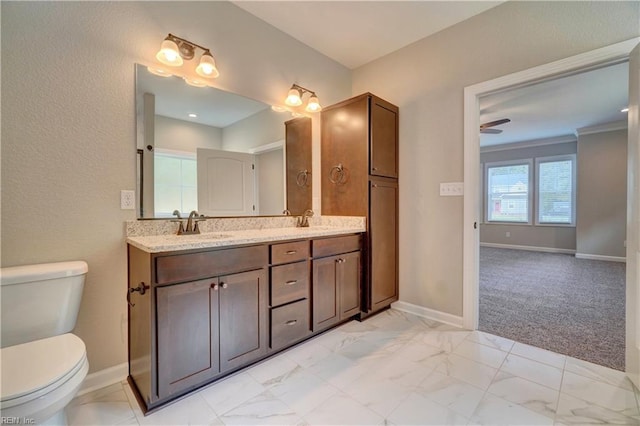 bathroom with vanity, toilet, ceiling fan, and crown molding