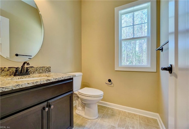 bathroom featuring tile patterned flooring, vanity, and toilet