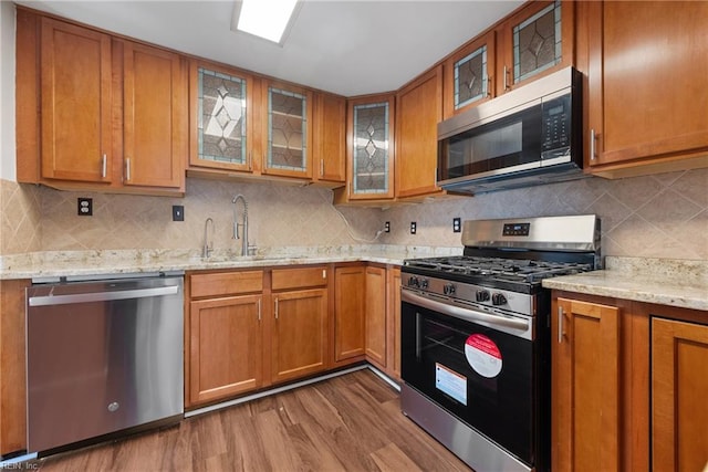 kitchen featuring hardwood / wood-style floors, decorative backsplash, sink, and stainless steel appliances