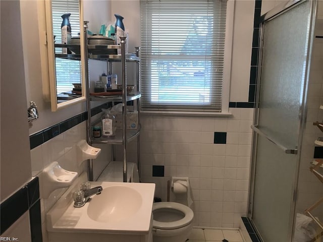 bathroom with toilet, tile patterned floors, tile walls, and walk in shower