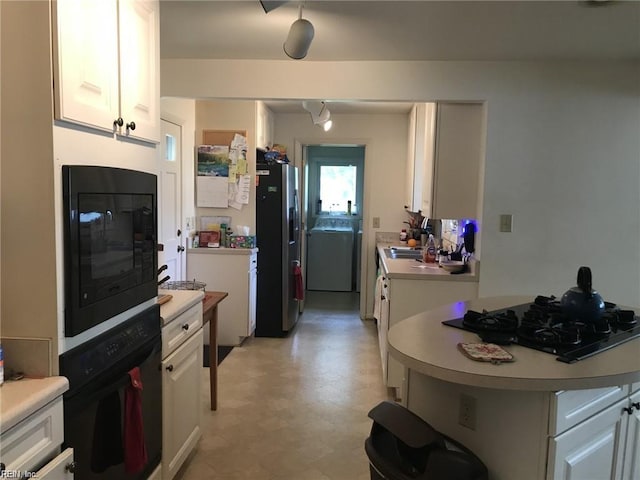 kitchen featuring sink, white cabinets, and black appliances