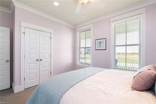 bedroom featuring ceiling fan, a closet, light carpet, and ornamental molding