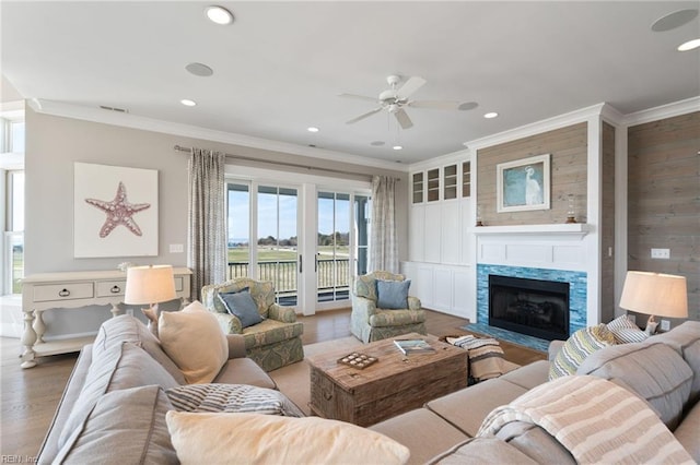 living room featuring hardwood / wood-style flooring, ceiling fan, and ornamental molding