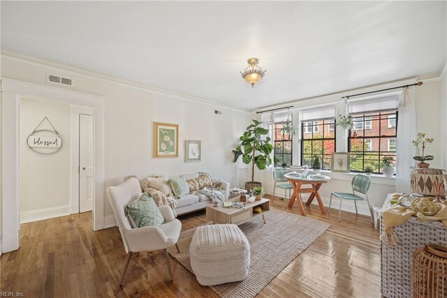 living room featuring hardwood / wood-style floors and crown molding