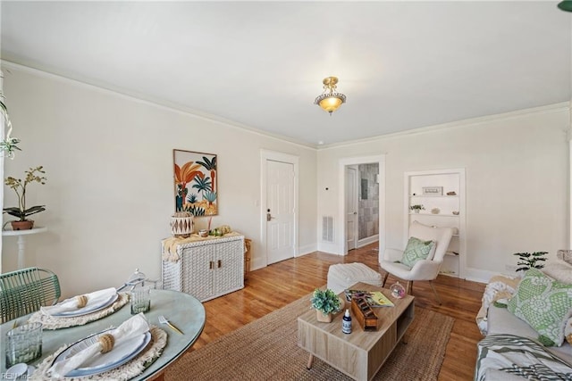 living room with wood-type flooring and ornamental molding