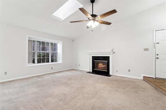 unfurnished living room featuring ceiling fan, light carpet, and lofted ceiling with skylight