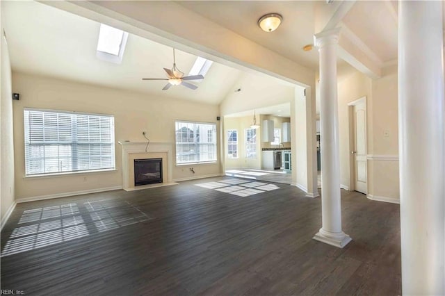 unfurnished living room with dark hardwood / wood-style flooring, decorative columns, high vaulted ceiling, and ceiling fan