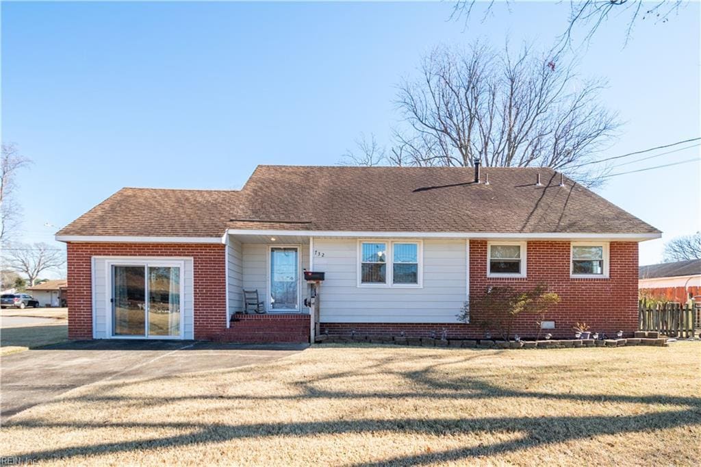 rear view of house featuring a yard