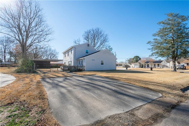 view of side of property with a carport and a lawn