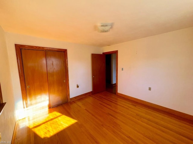 unfurnished bedroom with a closet and light wood-type flooring