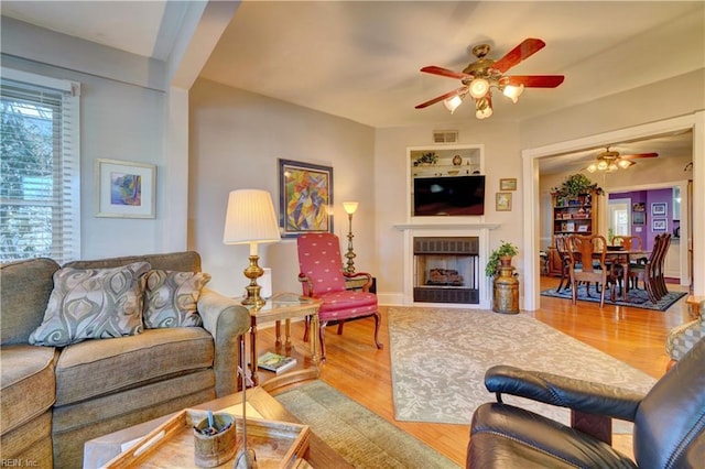 living room featuring ceiling fan and light wood-type flooring