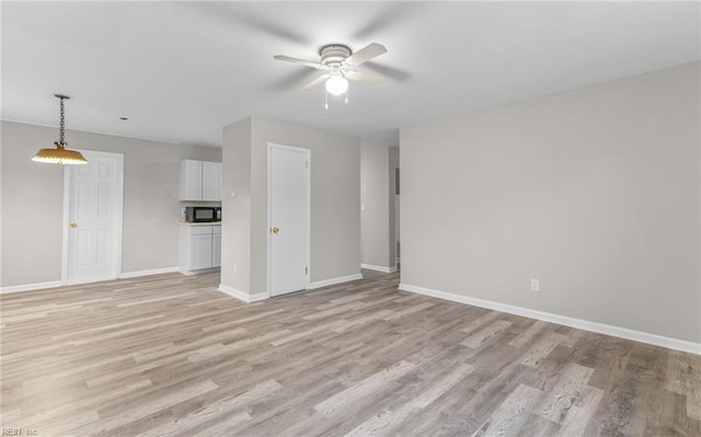 unfurnished living room featuring light wood-type flooring and ceiling fan