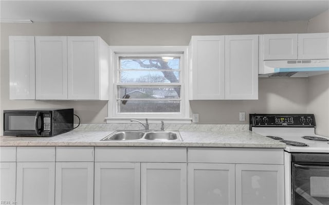 kitchen with electric stove, sink, and white cabinets