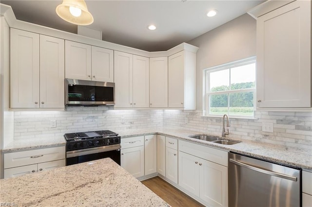 kitchen featuring white cabinets, backsplash, stainless steel appliances, and sink