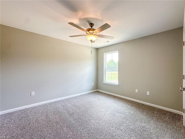 empty room featuring ceiling fan and carpet