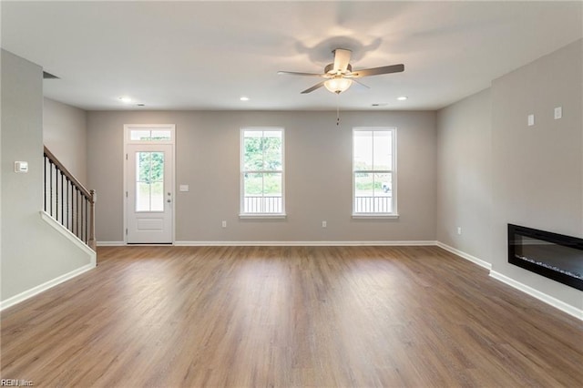 unfurnished living room featuring light hardwood / wood-style flooring and ceiling fan