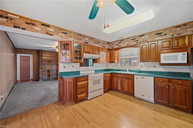 kitchen featuring brick wall, light wood-type flooring, white appliances, and sink