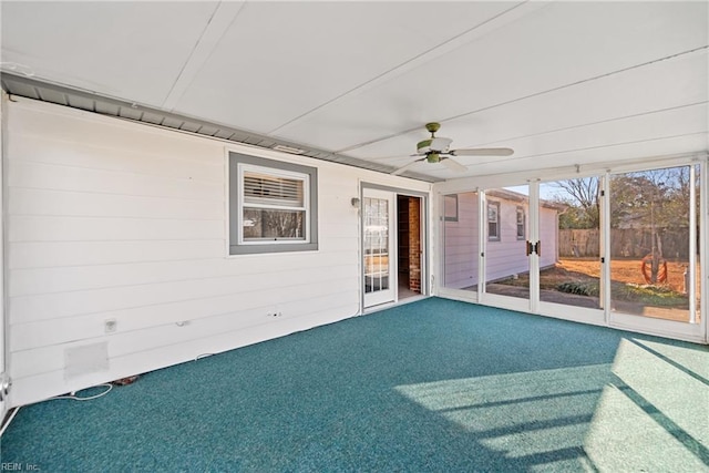 unfurnished sunroom featuring ceiling fan