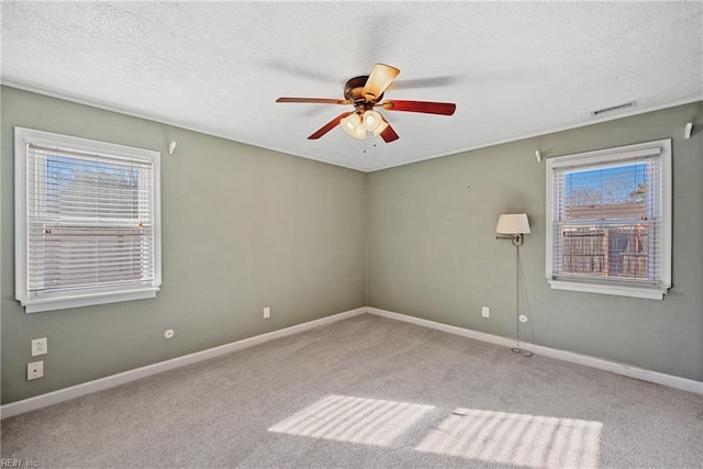 empty room with light carpet, ceiling fan, and a textured ceiling