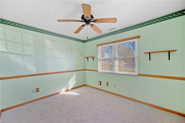 spare room with ceiling fan and light colored carpet