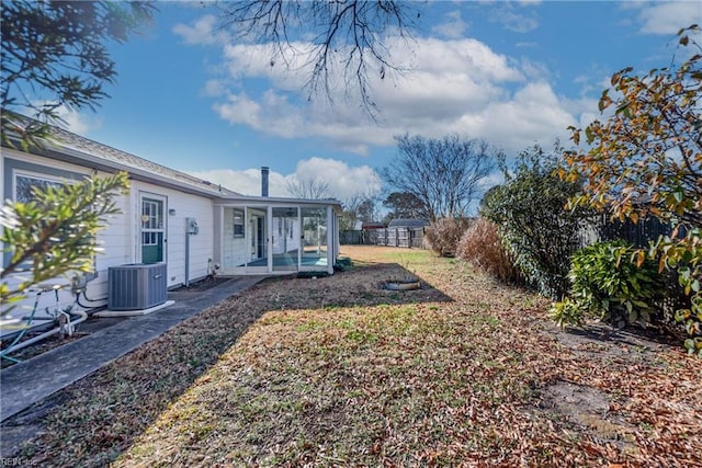 view of yard with central AC and a sunroom