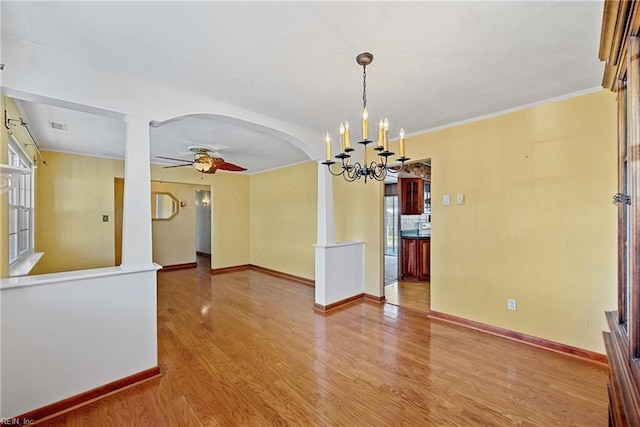 interior space featuring wood-type flooring, ceiling fan with notable chandelier, and ornamental molding