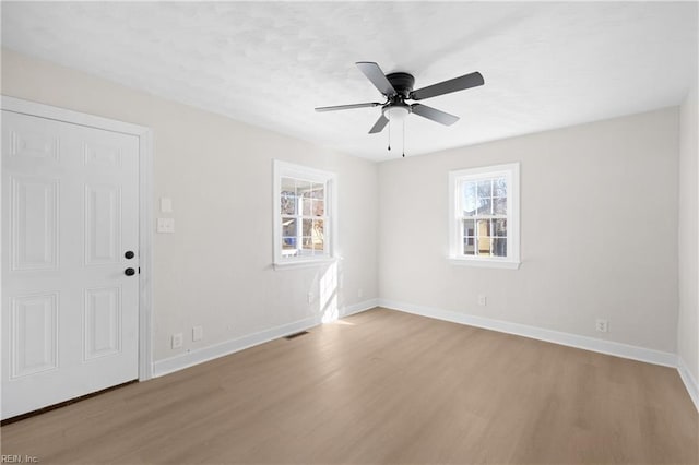 empty room featuring ceiling fan and light hardwood / wood-style floors