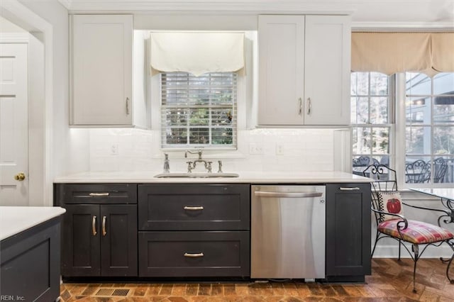 bar with white cabinets, backsplash, stainless steel dishwasher, and sink