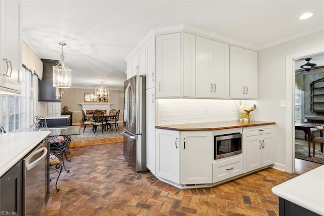 kitchen with white cabinets, stainless steel appliances, and hanging light fixtures