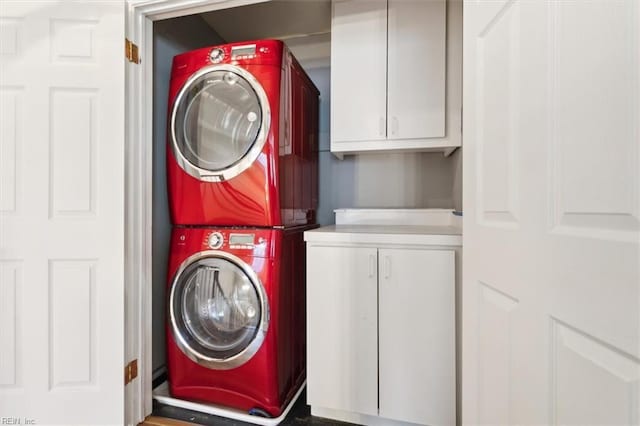 laundry area featuring cabinets and stacked washer / drying machine