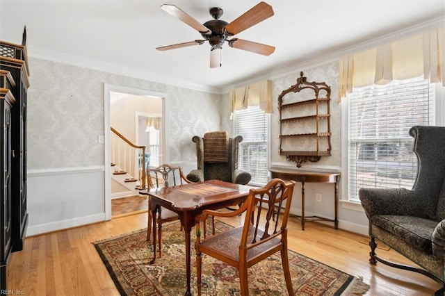 dining area with wood-type flooring, ceiling fan, and crown molding