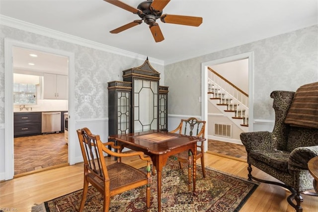 dining area with ceiling fan, crown molding, and light hardwood / wood-style flooring