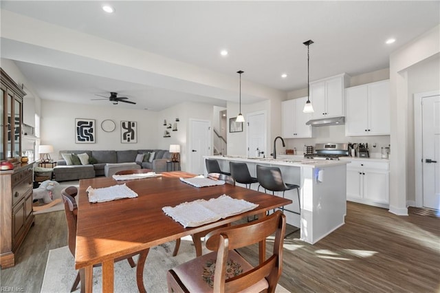 dining area featuring sink, ceiling fan, and dark wood-type flooring