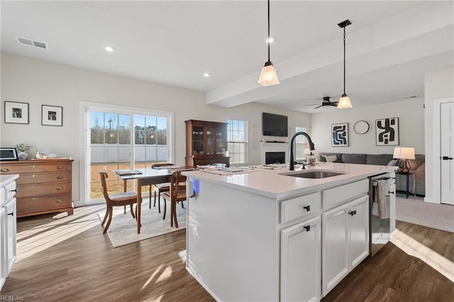 kitchen featuring sink, white cabinetry, ceiling fan, pendant lighting, and a kitchen island with sink