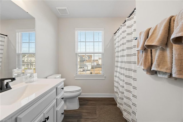 bathroom featuring hardwood / wood-style floors, toilet, a healthy amount of sunlight, and vanity