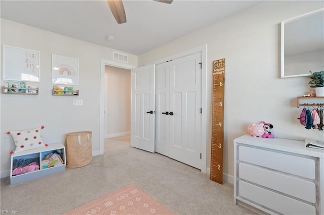 bedroom featuring light carpet, a closet, and ceiling fan