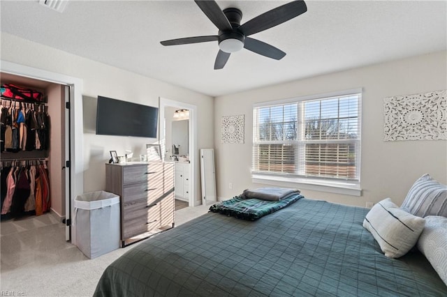 bedroom with ceiling fan, a spacious closet, a closet, and light carpet