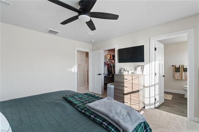 bedroom featuring ceiling fan, a spacious closet, ensuite bathroom, and a closet